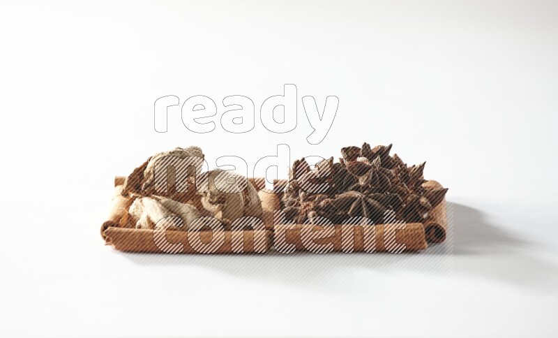 2 squares of cinnamon sticks full of star anise and dried ginger on white flooring