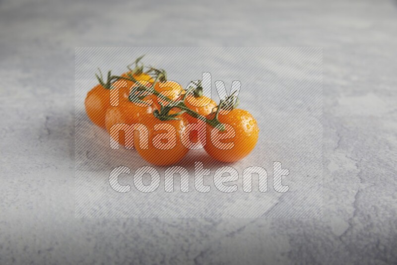 Orange cherry tomato vein on a light grey textured background 45 degree