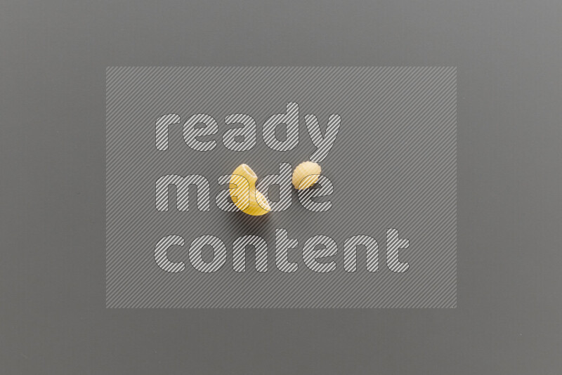 Elbow pasta with other types of pasta on grey background