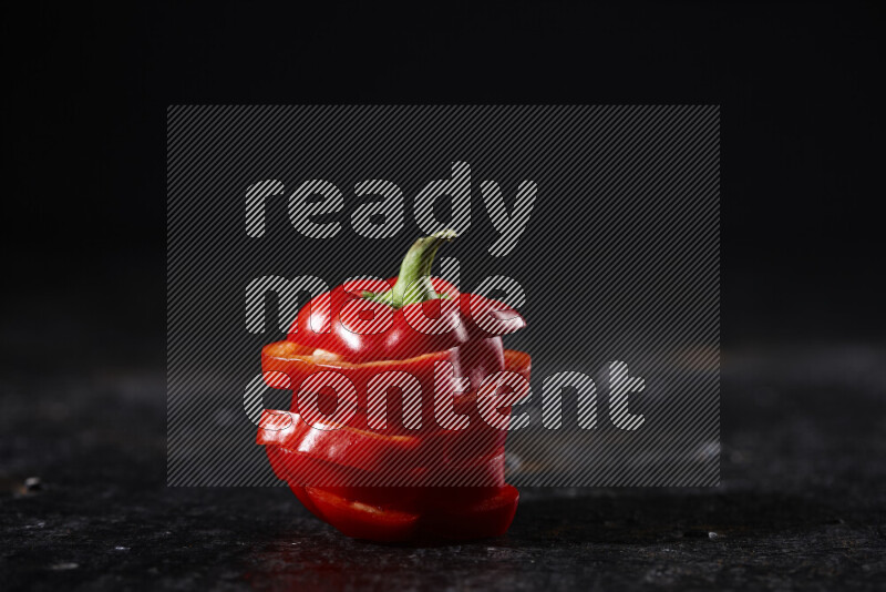 Red bell pepper slices on black background
