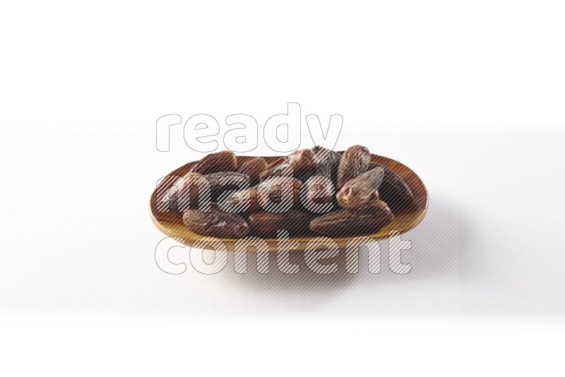 Dates in a wooden plate on white background