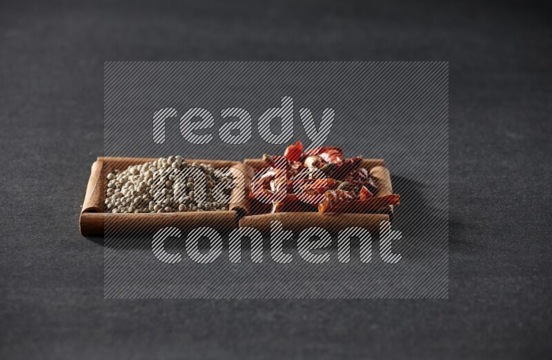 2 squares of cinnamon sticks full of chilis and white peppers on black flooring