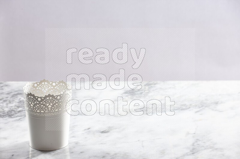 An empty white plant pot on grey marble background
