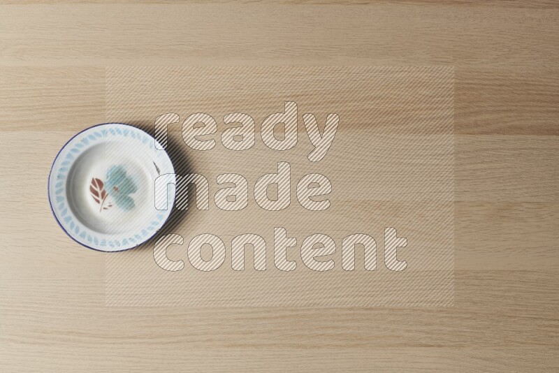 A vintage metal plate on light wooden background