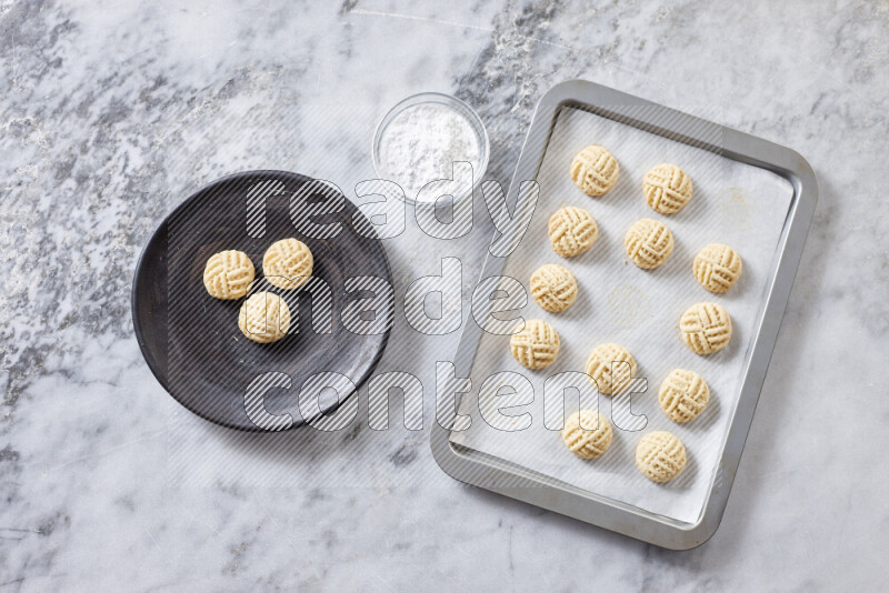 كحك خطوة بخطوة بمكوناته سمن، سكر، دقيق، سمسم، خميرة، ماء ونكهة الكحك على خلفية رخام رمادي