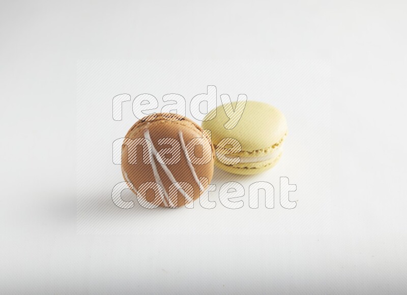 45º Shot of of two assorted Brown Irish Cream, and Yellow Lime macarons on white background