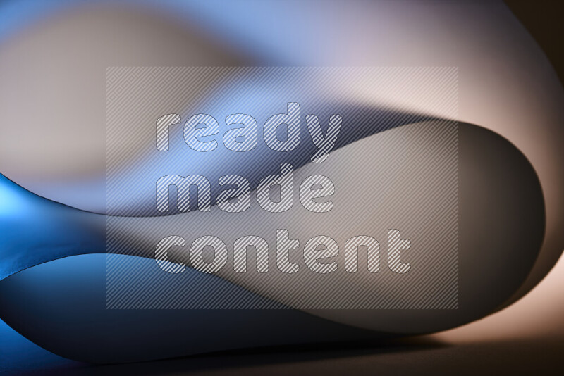 An abstract art piece displaying smooth curves in blue and white gradients created by colored light