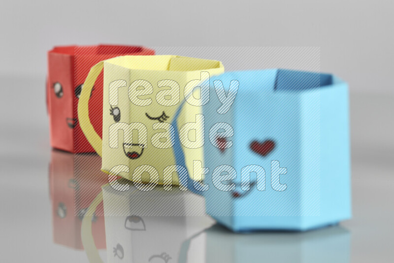 Origami cup on grey background