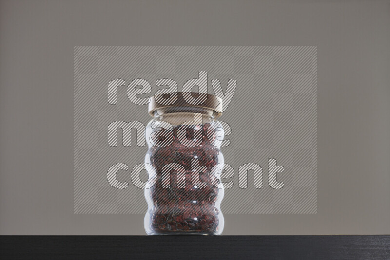 Sequins in a glass jar on black background