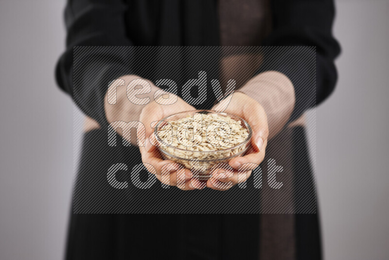 Woman in abaya holding different kinds of legumes in different positions