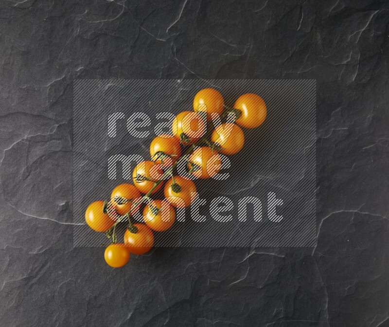 single cherry tomato vein topview on a black slate background