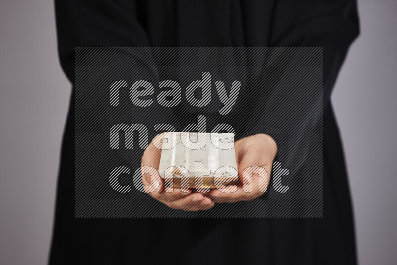 A woman in black abaya holding different pottery essentials in different positions