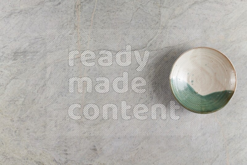 A decorative pottery plate on grey marble background