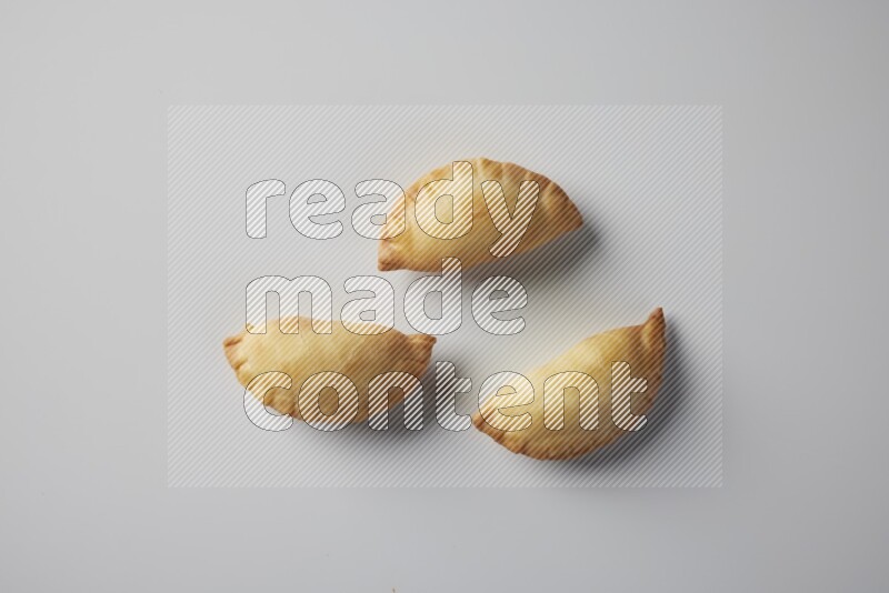 Three fried sambosa from a top angle on a white background