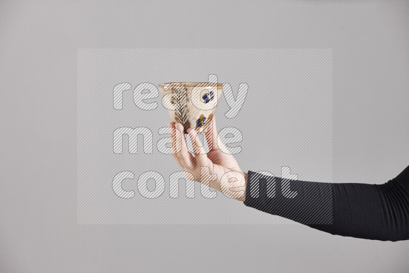A woman in black abaya holding different pottery essentials in different positions