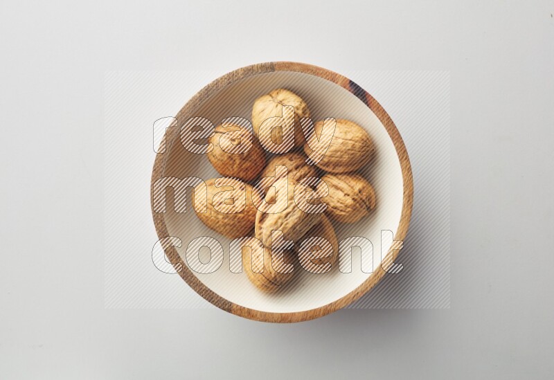 Top-view shot of walnut in a container on white background
