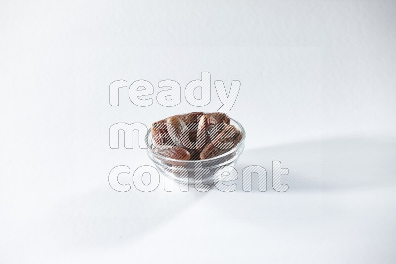 A glass bowl full of dried dates on a white background in different angles