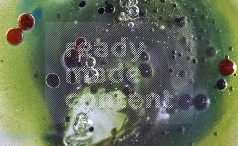 Close-ups of abstract red, green and blue watercolor drops on oil Surface on green background