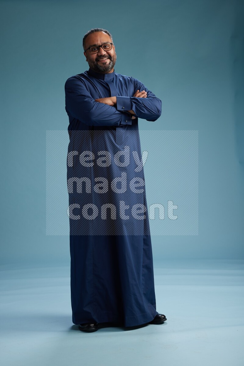 Saudi Man without shimag Standing Interacting with the camera on blue background