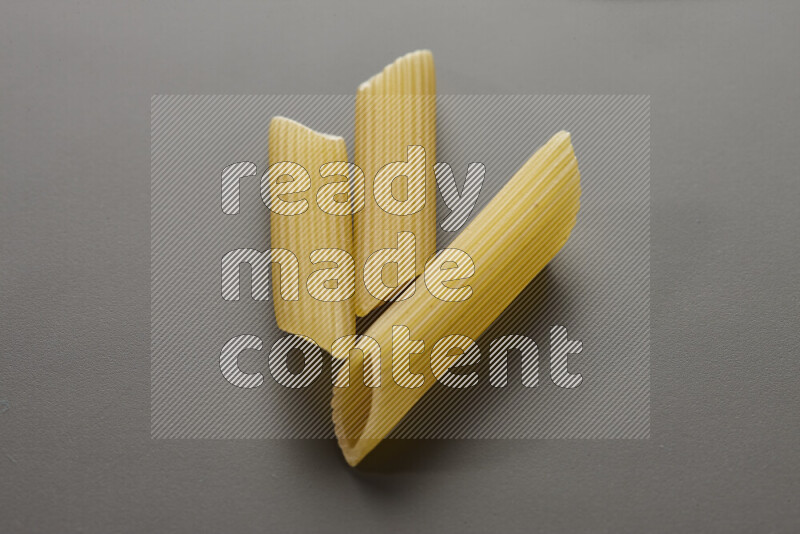 Penne pasta on grey background