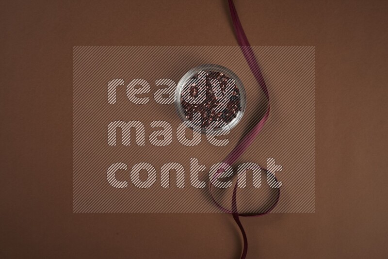 مجموعة من أدوات الخياطة والتفصيل حمراء اللون على خلفية بنية