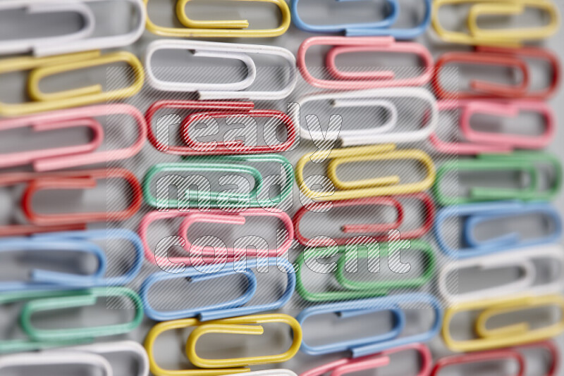 Multicolored paper clips isolated on a grey background