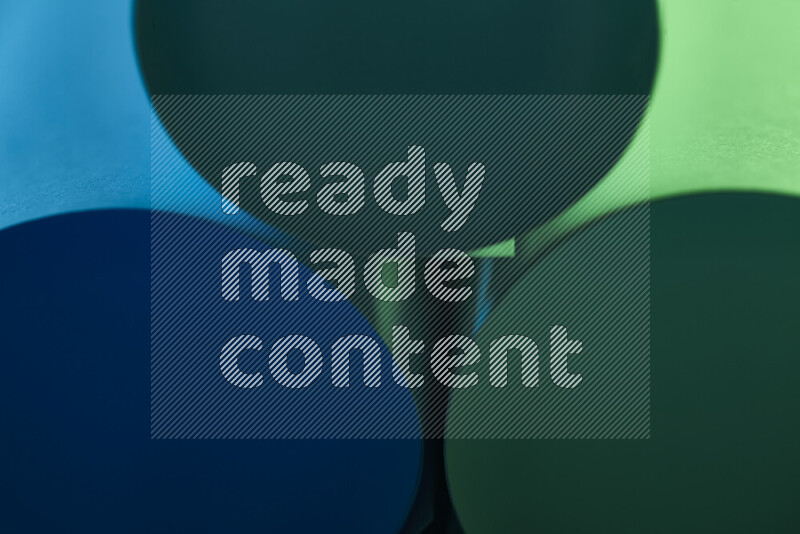 The image shows an abstract paper art with circular shapes in varying shades of green and blue