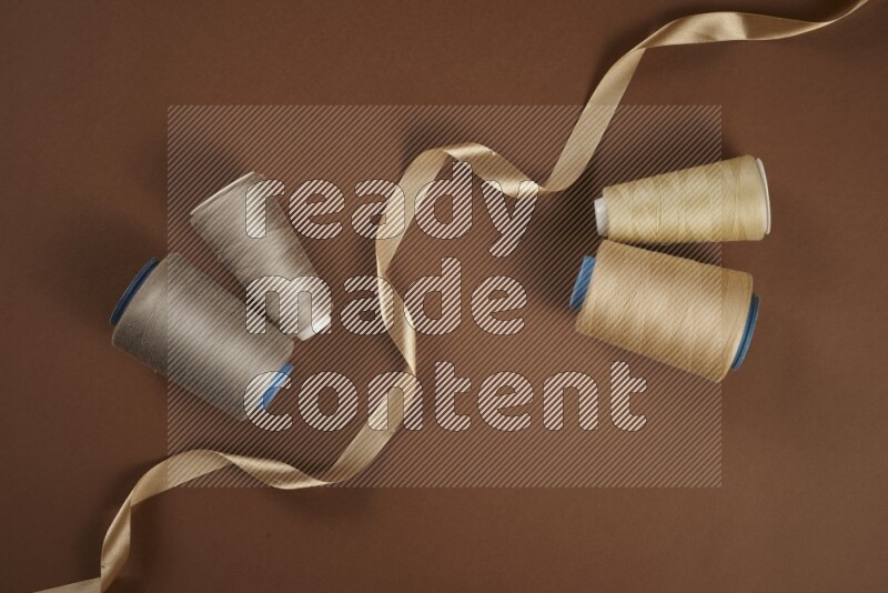 A brown collection of sewing and tailoring tools arranged on a brown background