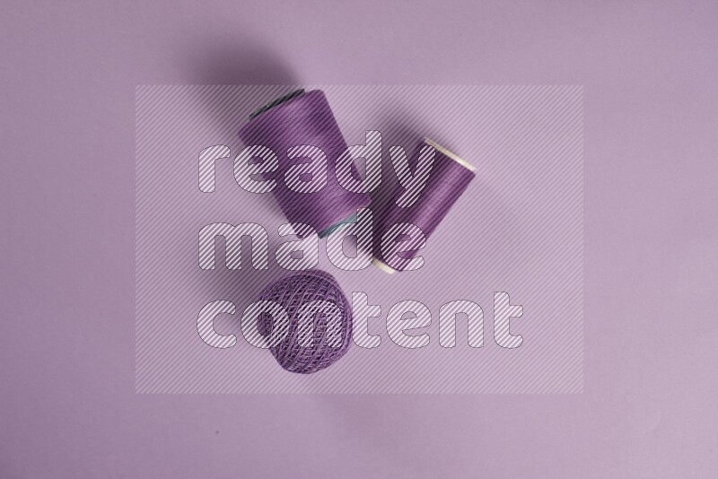 A purple collection of sewing and tailoring tools arranged on a purple background