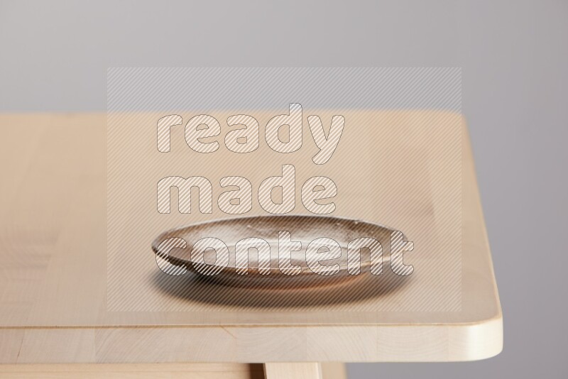multi-colored pottery Plate on a wooden table edge