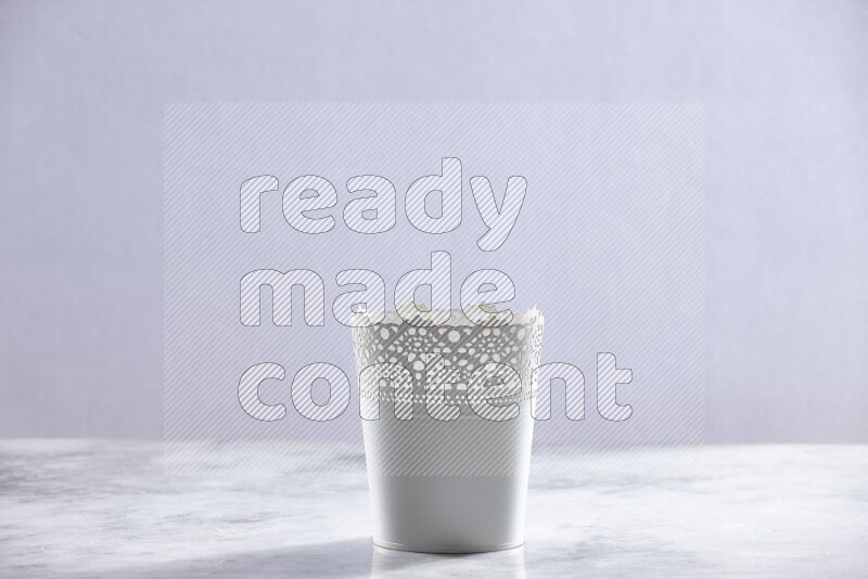 An empty white plant pot on grey marble background