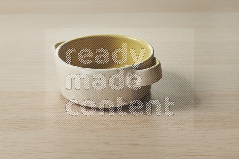 A multicolored pottery bowl on light wooden background