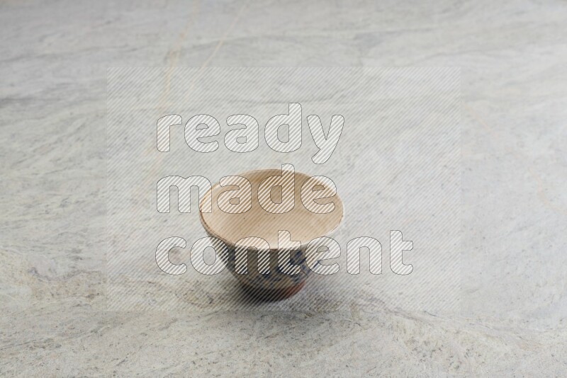 A multicolored pottery bowl on grey marble background