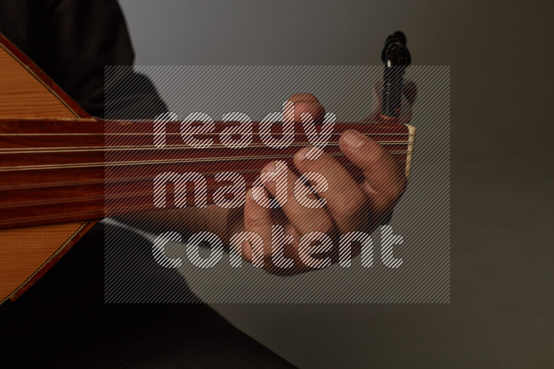 a hand intracting with a wooden brown Oud