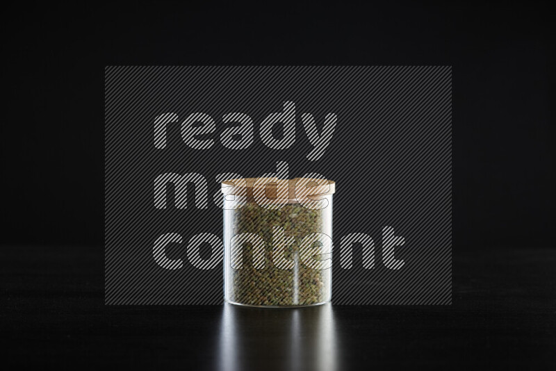 Freekeh in a glass jar on black background