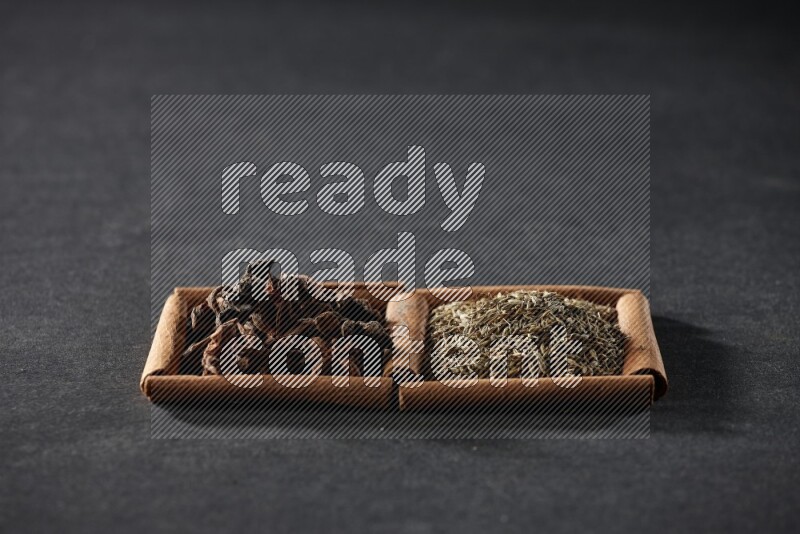 2 squares of cinnamon sticks full of cumin and star anise on black flooring