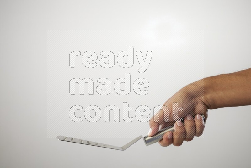 Male Hand Holding Burger Flipper on white background