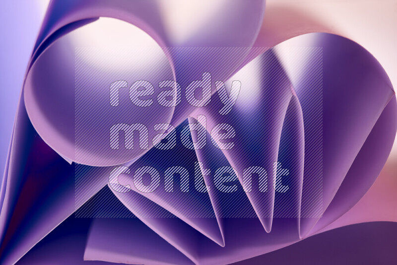 An artistic display of paper folds creating a harmonious blend of geometric shapes, highlighted by soft lighting in purple tones