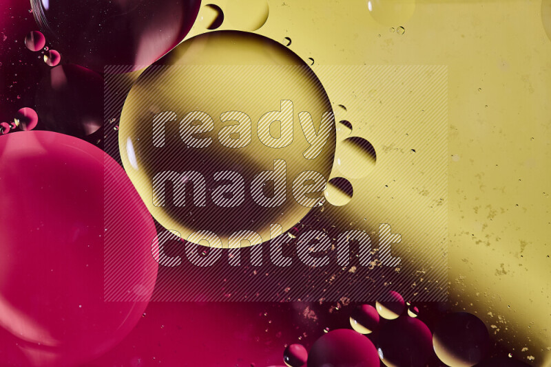 Close-ups of abstract oil bubbles on water surface in shades of yellow and pink