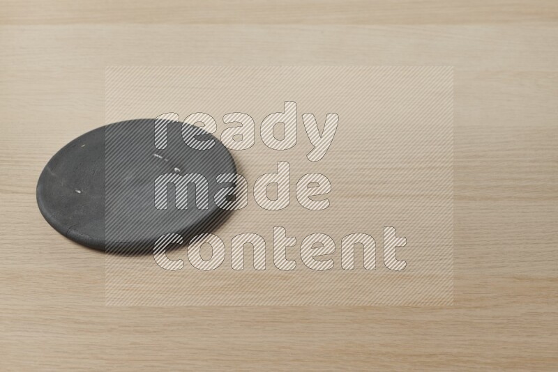 A pottery coaster on light wooden background