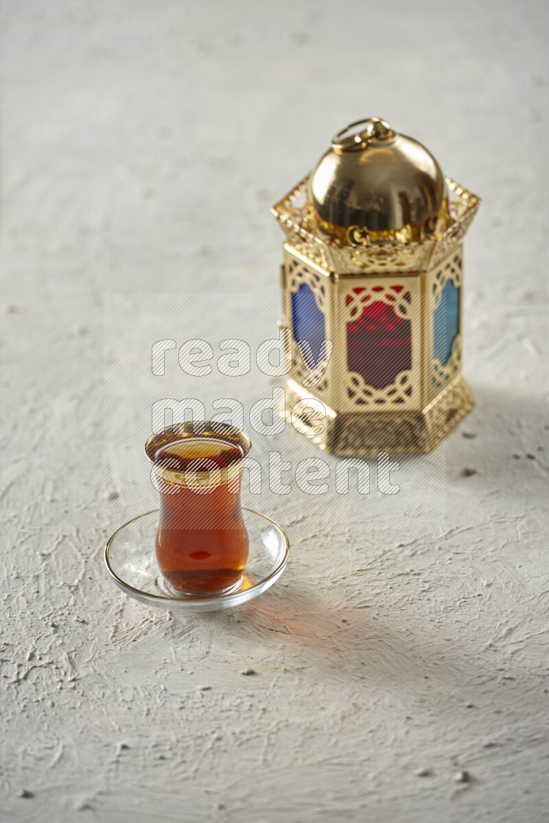 A golden lantern with different drinks, dates, nuts, prayer beads and quran on textured white background