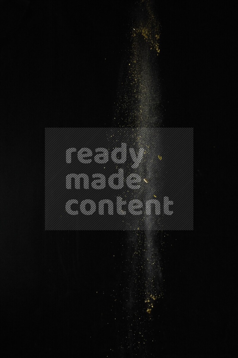 A side view of yellow powder explosion on black background