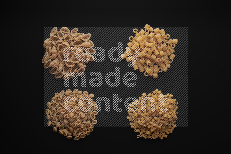Different pasta types in bunches on black background