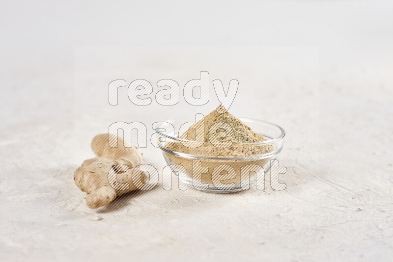 A glass bowl full of ground ginger powder on white background