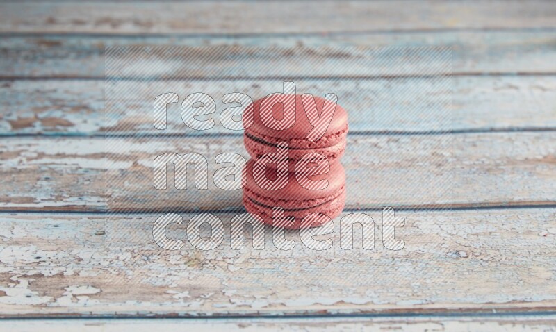 45º Shot of two Pink Raspberry macarons on light blue wooden background
