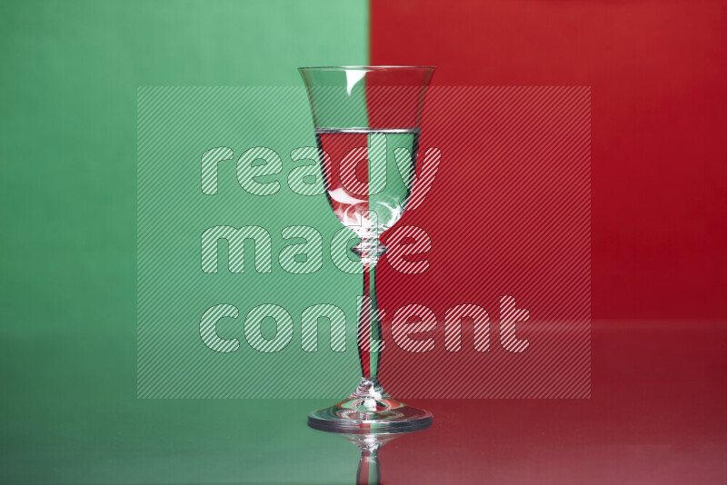 The image features a clear glassware filled with water, set against green and red background