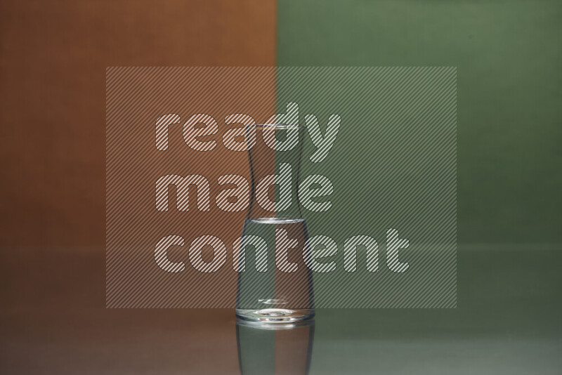 The image features a clear glassware filled with water, set against brown and dark green background