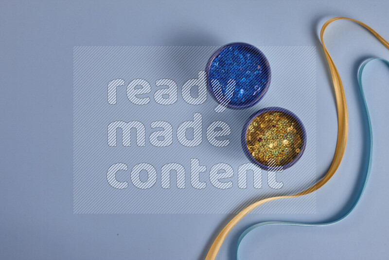 مجموعة من أدوات الخياطة والتفصيل صفراء وزرقاء اللون على خلفية زرقاء