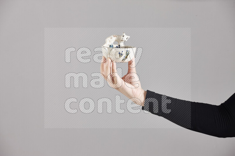 A woman in black abaya holding different pottery essentials in different positions