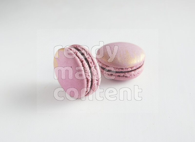 45º Shot of two Purple Strawberry macarons on white background